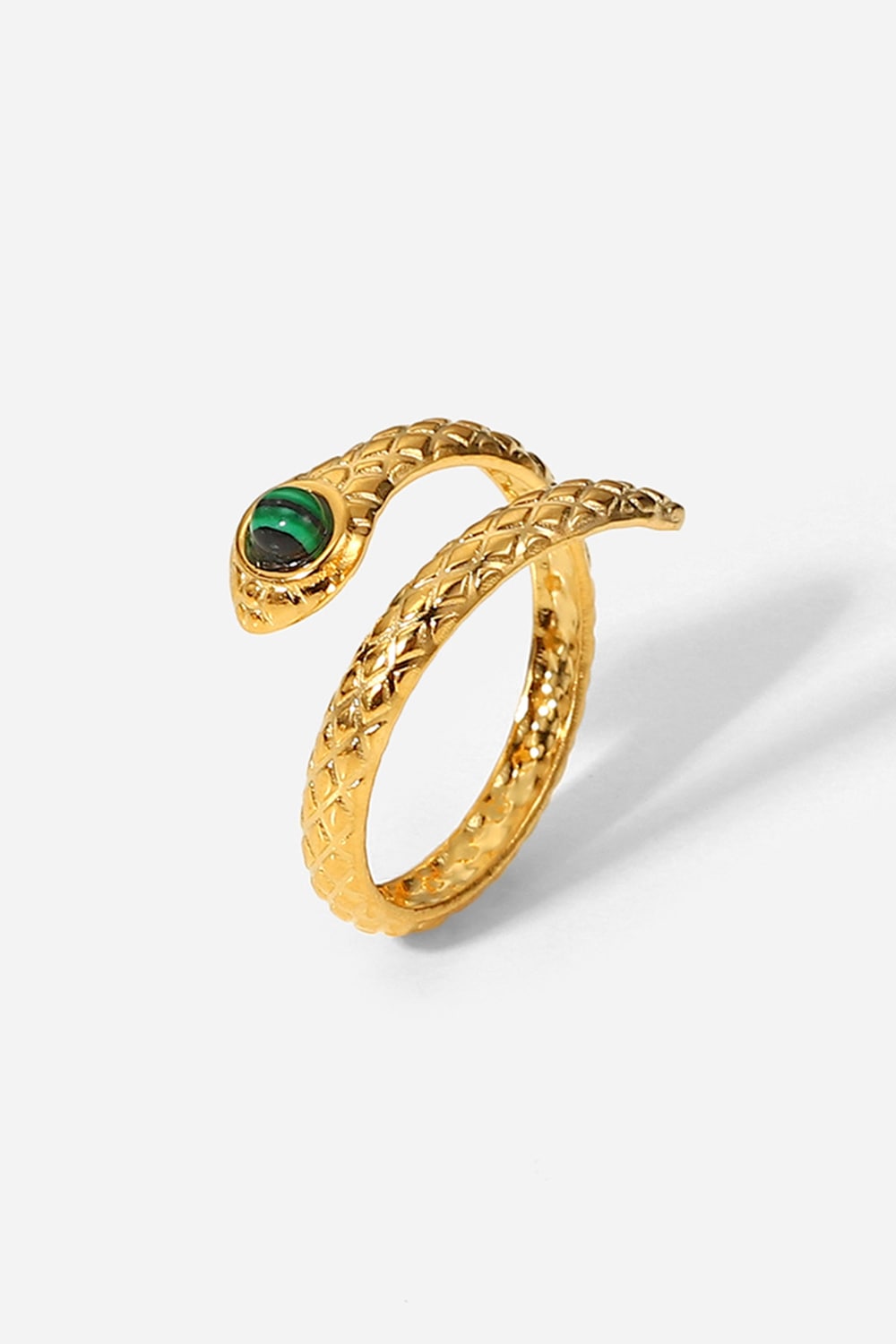 Gold snake-shaped ring with a green gemstone on a white background
