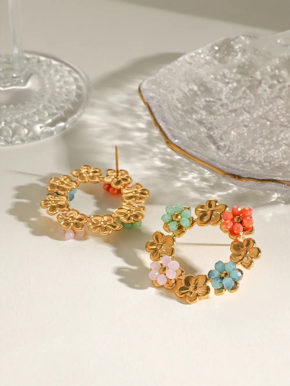Gold plated stainless steel flower earrings with colorful synthetic crystals arranged in a circular floral design