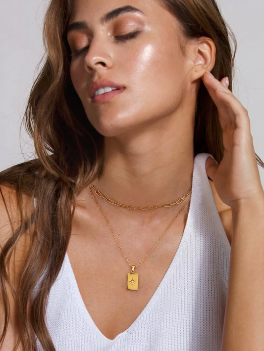 Woman wearing an 18K gold-plated stainless steel double-layered necklace with a rectangular zircon pendant and chain links
