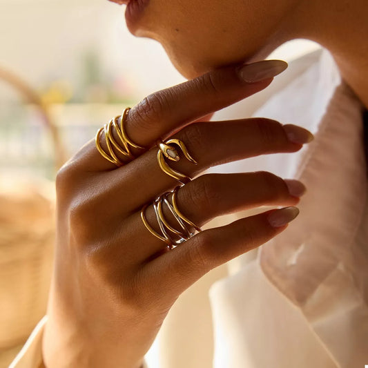 Close-up of a hand wearing adjustable two-tone open rings made of 18K gold-plated stainless steel.