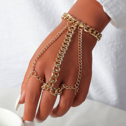 Hand wearing multiple gold chain bracelets on a white background
