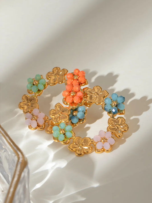 Gold-plated stainless steel flower earrings with colorful synthetic crystal clusters in green, orange, blue, and pink tones.
